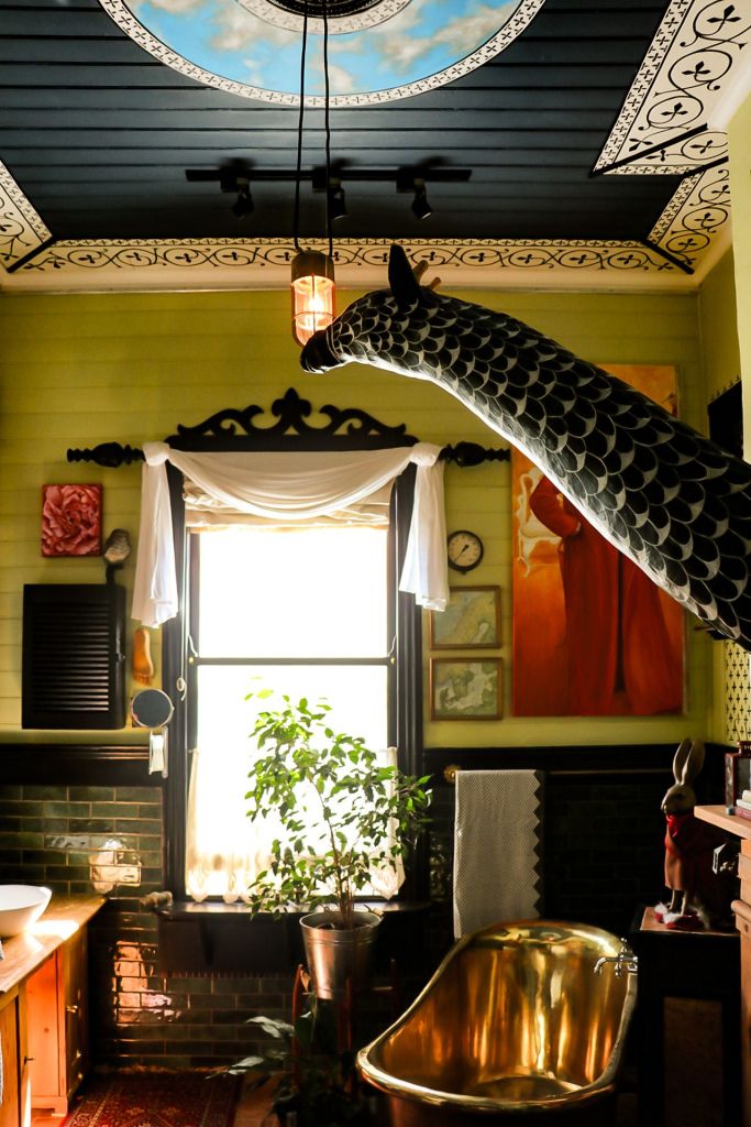 Giraffe and brass tub in bathroom